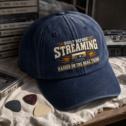 Vintage washed cap with printed Built Before Streaming Raised On The Real Thing slogan, angled view