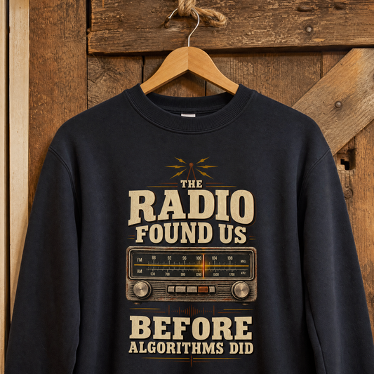 Black vintage sweatshirt hanging on wooden wall with printed radio slogan design