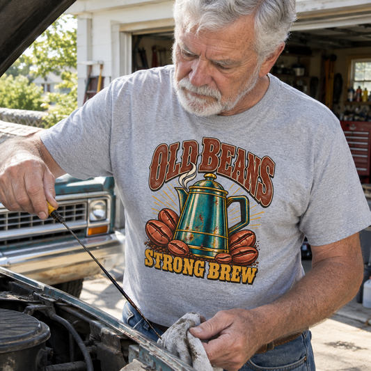 Senior man wearing gray vintage t-shirt with Old Beans Strong Brew printed design, working in garage
