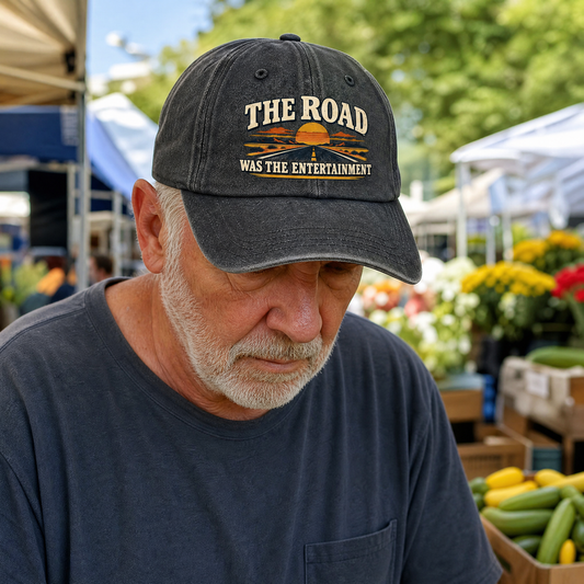 Black vintage washed cap with printed The Road Was The Entertainment, worn by senior man.