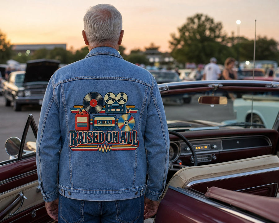 Man seen from behind in the denim jacket at an evening car show