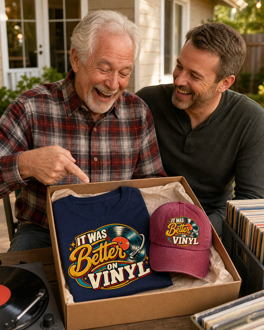 A dad laughing at the navy tee and wine red cap he just unwrapped on Father's Day