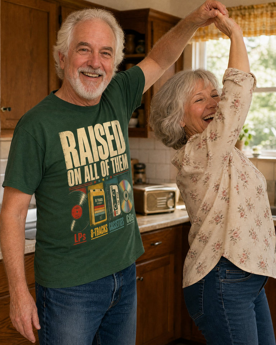 A couple dancing in the kitchen to the radio, he wears the forest green tee