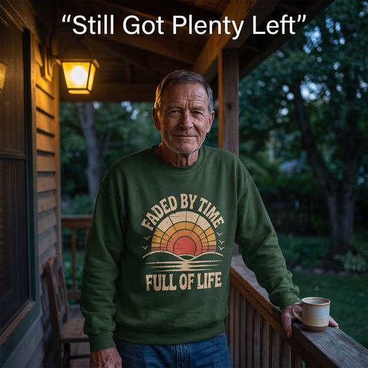 Senior man wearing green sweatshirt on porch, holding mug with quote text