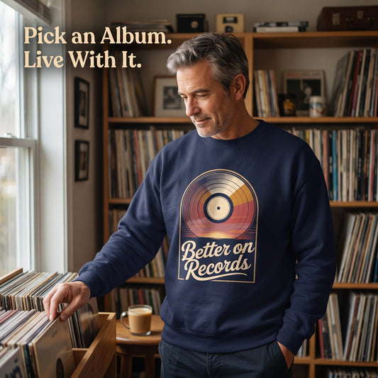 Man wearing navy sweatshirt browsing records by window with quote text