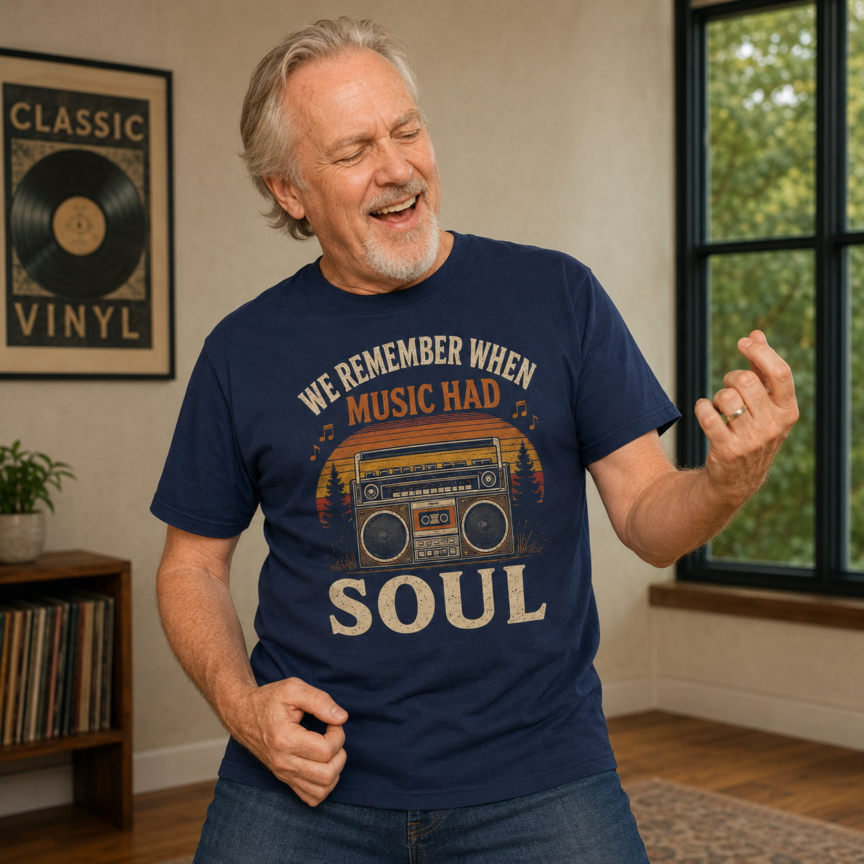 A smiling older man wearing a navy graphic T-shirt with a vintage boombox and the words 'WE REMEMBER WHEN MUSIC HAD SOUL' in a living room setting.