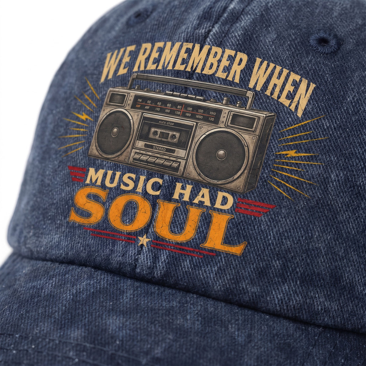 Close-up of a blue denim baseball cap featuring a vintage boombox graphic and the text 'WE REMEMBER WHEN MUSIC HAD SOUL' in tan and orange lettering.