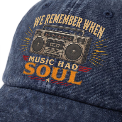Close-up of a blue denim baseball cap featuring a vintage boombox graphic and the text 'WE REMEMBER WHEN MUSIC HAD SOUL' in tan and orange lettering.