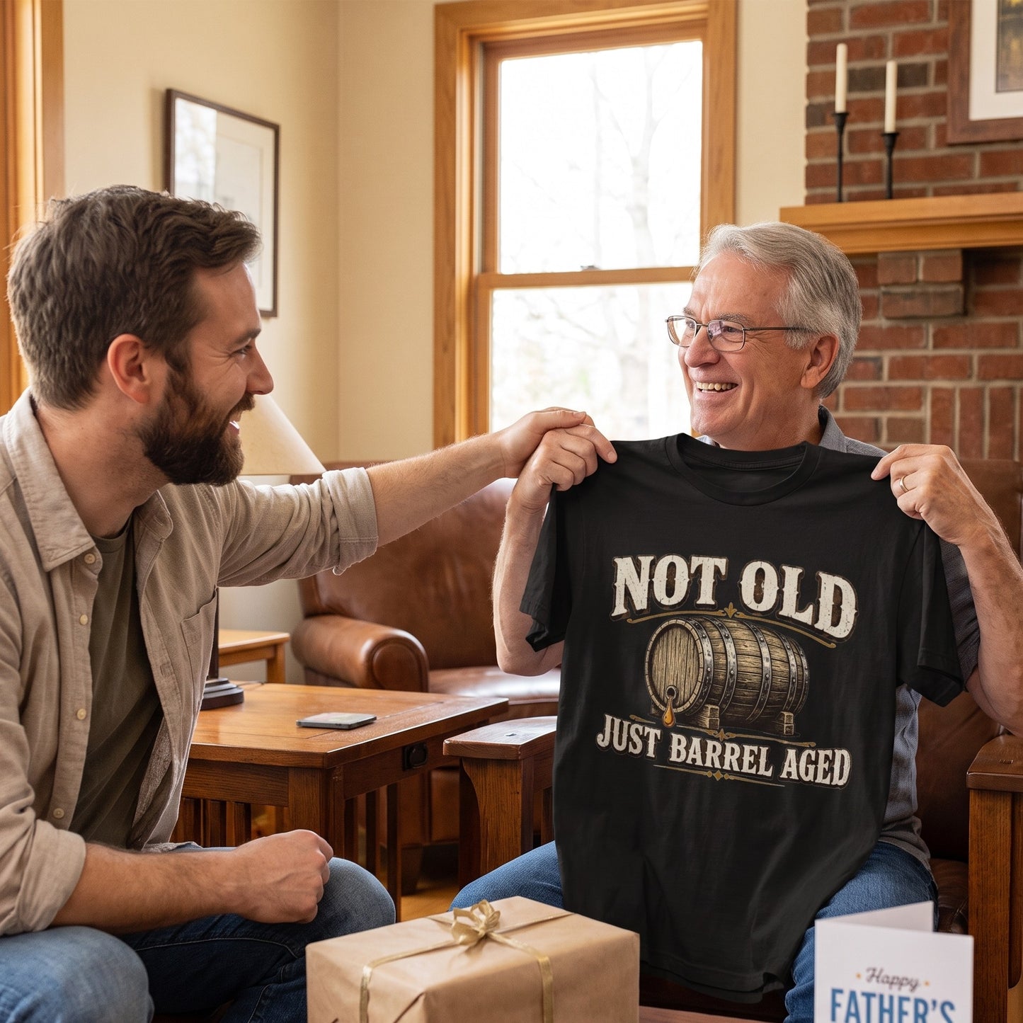 Man holding black T-shirt gift beside wrapped package and fireplace
