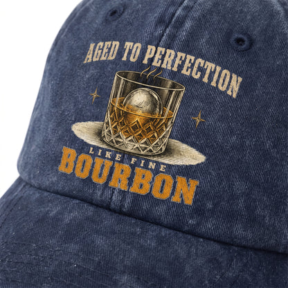 Close-up navy washed cap with Aged To Perfection bourbon glass printed graphic