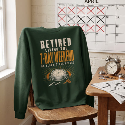 Folded forest green sweatshirt showing Retired. Living the 7-Day Weekend. No Alarm Clock printed graphic design
