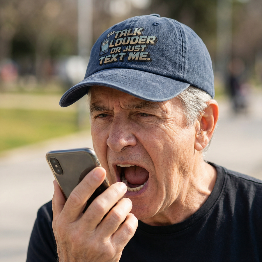 Older man wearing navy Talk Louder cap while speaking into phone
