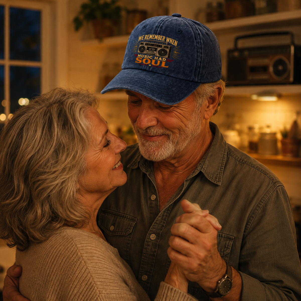 An older couple dancing closely in a warmly lit home interior. The man wears a blue baseball cap with embroidered text reading 'WE REMEMBER WHEN WE WERE YOU AND SOUL' and a dark button-up shirt.