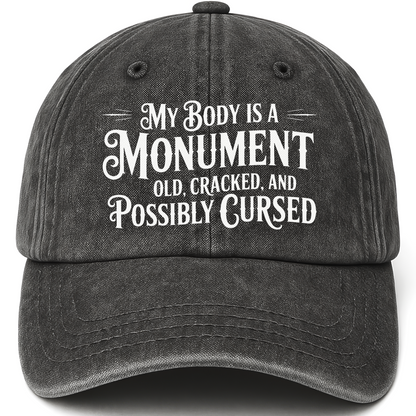 Black vintage washed cap with “My Body Is a Monument. Old, Cracked, and Possibly Cursed.” Gothic Humor Script Cap printed fro