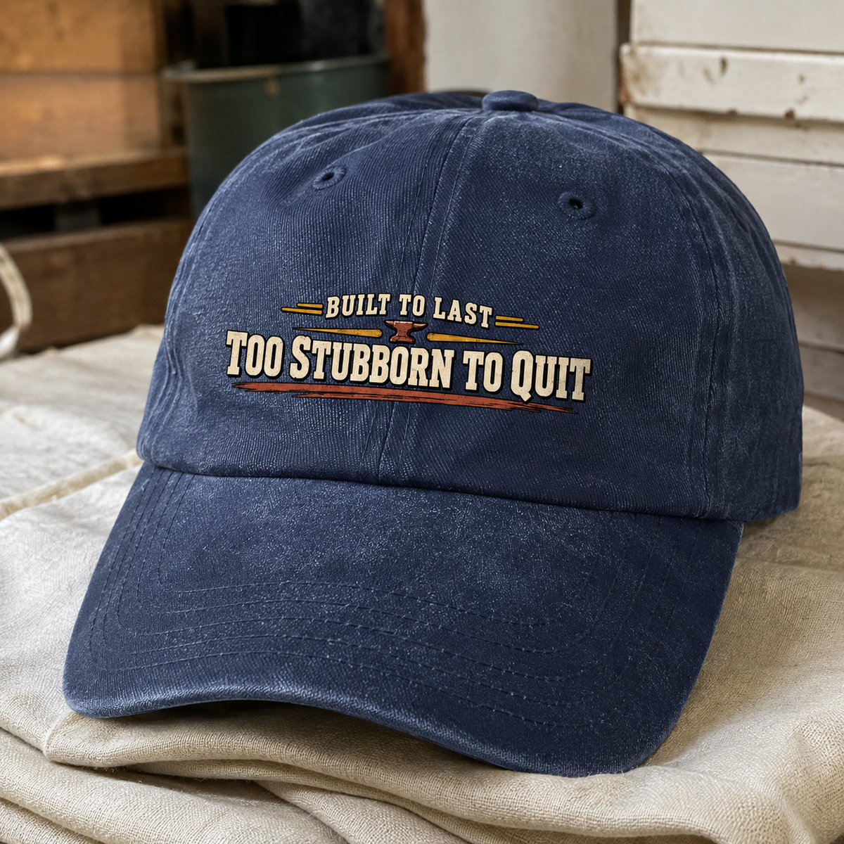 Blue vintage washed cap with printed Built To Last Too Stubborn To Quit slogan angled