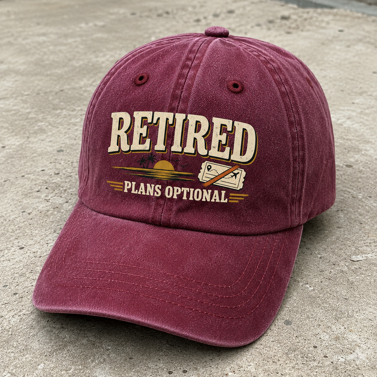 Vintage washed cap in burgundy with printed Retired Plans Optional slogan, angled view