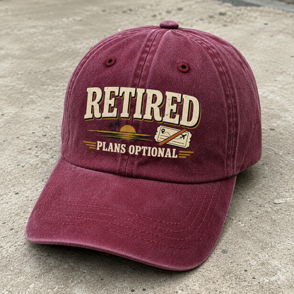 Vintage washed cap in burgundy with printed Retired Plans Optional slogan, angled view