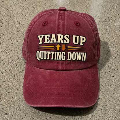 Burgundy vintage washed cap with printed Years Up Quitting Down slogan front angle