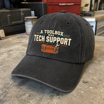 Black vintage washed cap with printed “A Toolbox Was Tech Support” design, angled view.