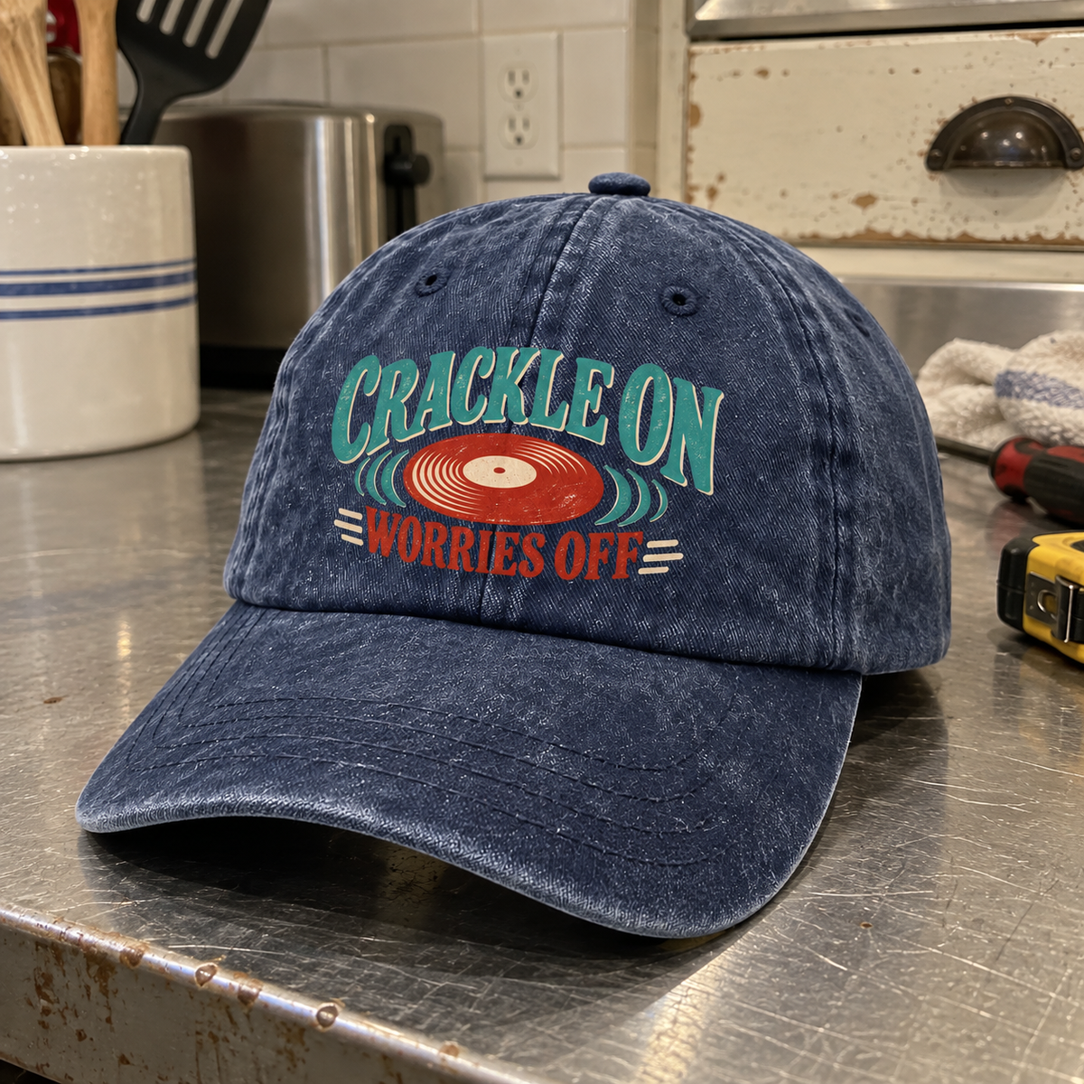 Angled view of navy vintage washed cap with printed Crackle On Worries Off record design