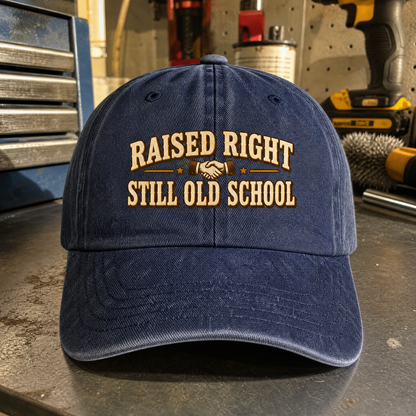 Blue vintage washed cap with printed “Raised Right Still Old School” slogan, front angle view