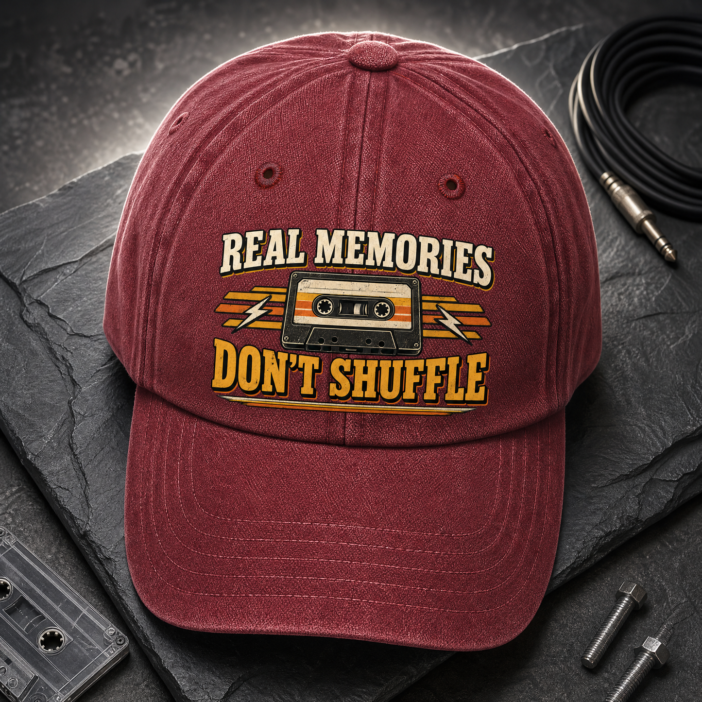 Burgundy vintage washed cap with printed Real Memories Don’t Shuffle cassette design, angled view
