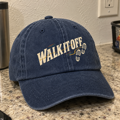Navy vintage washed cap with printed Walk It Off slogan and footprint design, angled view