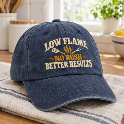 Blue vintage washed cap with printed Low Flame. No Rush Better Results slogan, angled view.