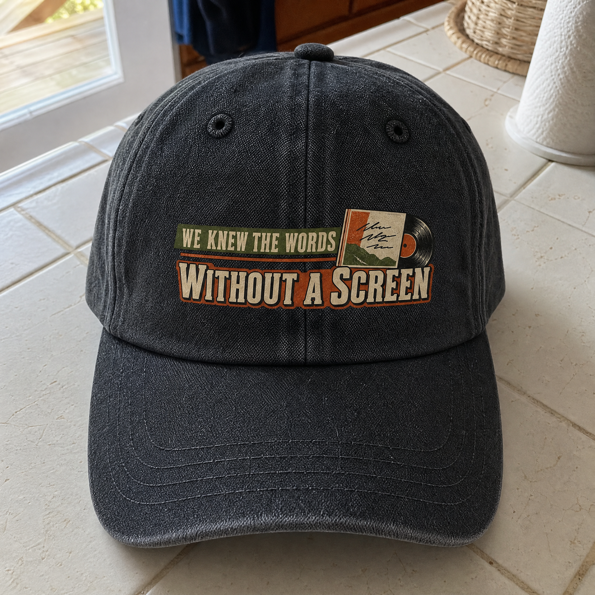 Black vintage washed cap with printed “We Knew the Words Without a Screen” slogan, angled.