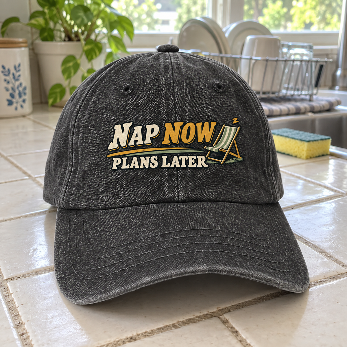 Charcoal vintage washed cap with printed Nap Now Plans Later design on tiled counter