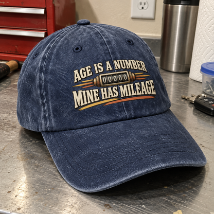 Angled navy vintage washed cap with printed Age Is A Number Mine Has Mileage slogan