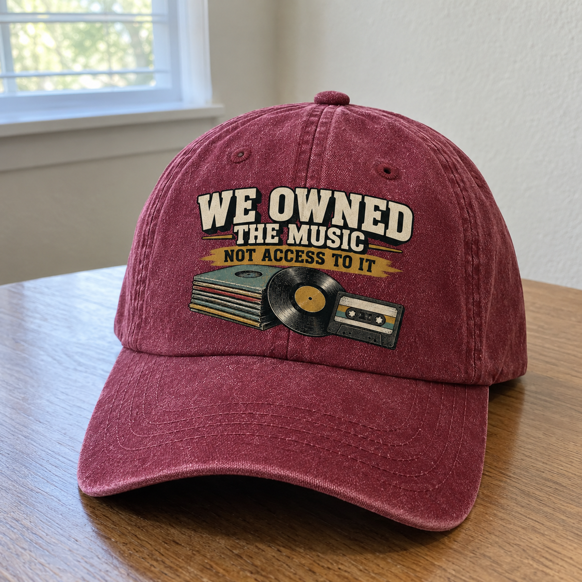 Burgundy vintage washed cap with printed “We Owned The Music. Not Access To It” design, angled view