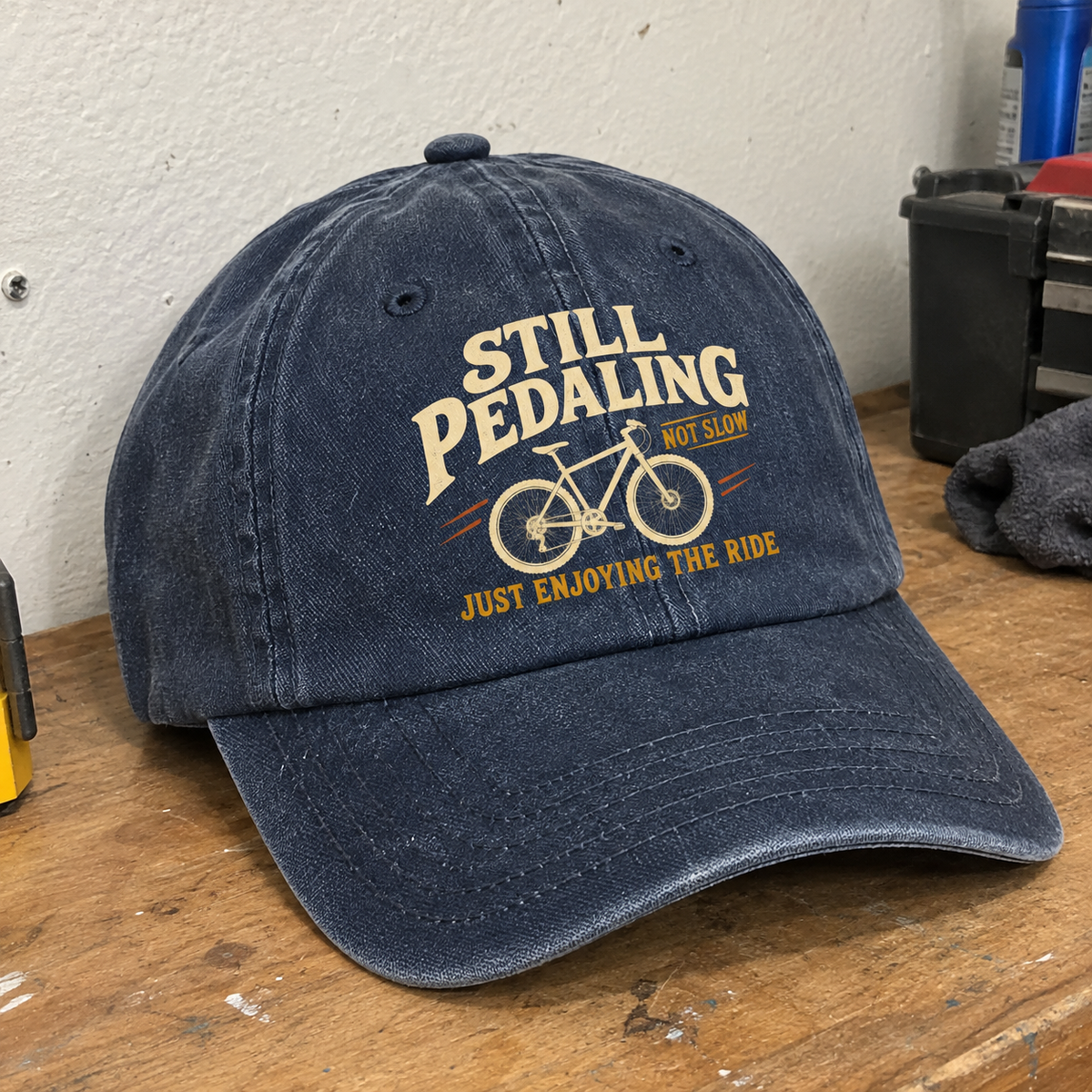 Navy vintage washed cap with printed Still Pedaling slogan and bicycle design