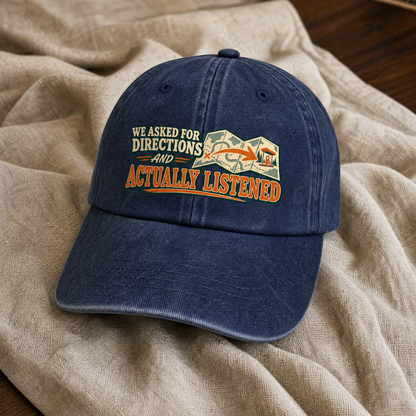 Navy vintage washed cap with printed “We Asked For Directions And Actually Listened,” angled view.
