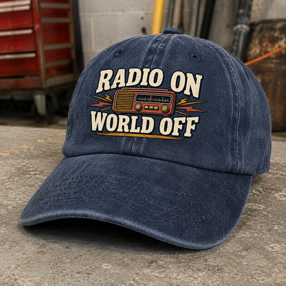 Navy vintage washed cap with printed Radio On World Off slogan, angled view