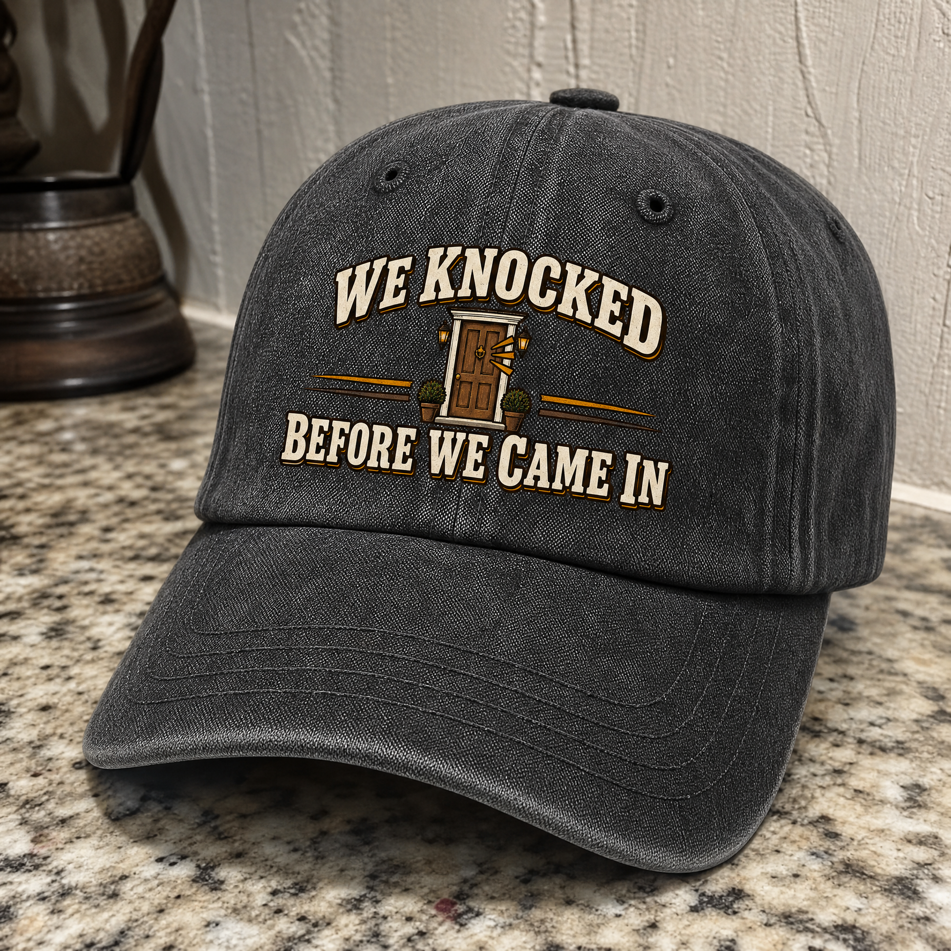 Black vintage washed cap with printed WE KNOCKED BEFORE WE CAME IN slogan, angled view