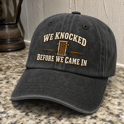 Black vintage washed cap with printed WE KNOCKED BEFORE WE CAME IN slogan, angled view