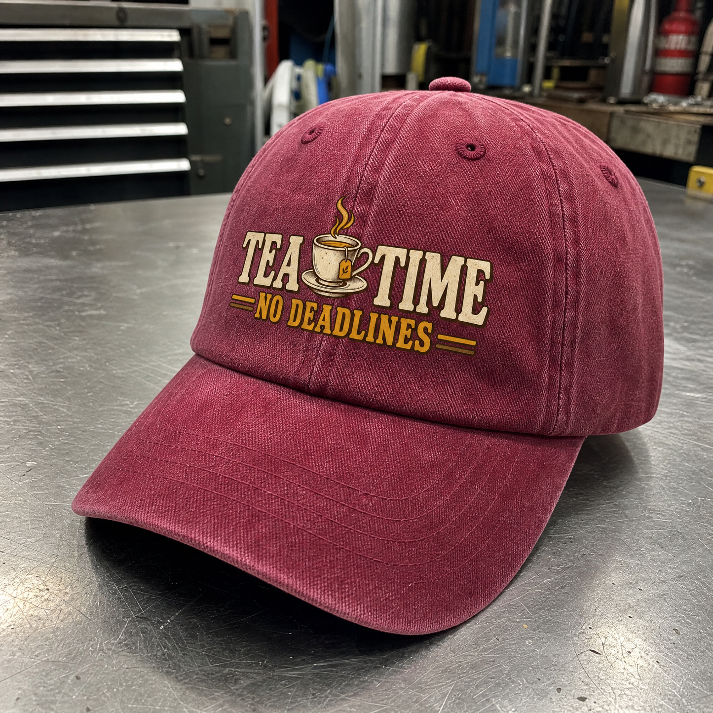 Burgundy vintage washed cap with printed “Tea Time. No Deadlines” slogan, angled view.