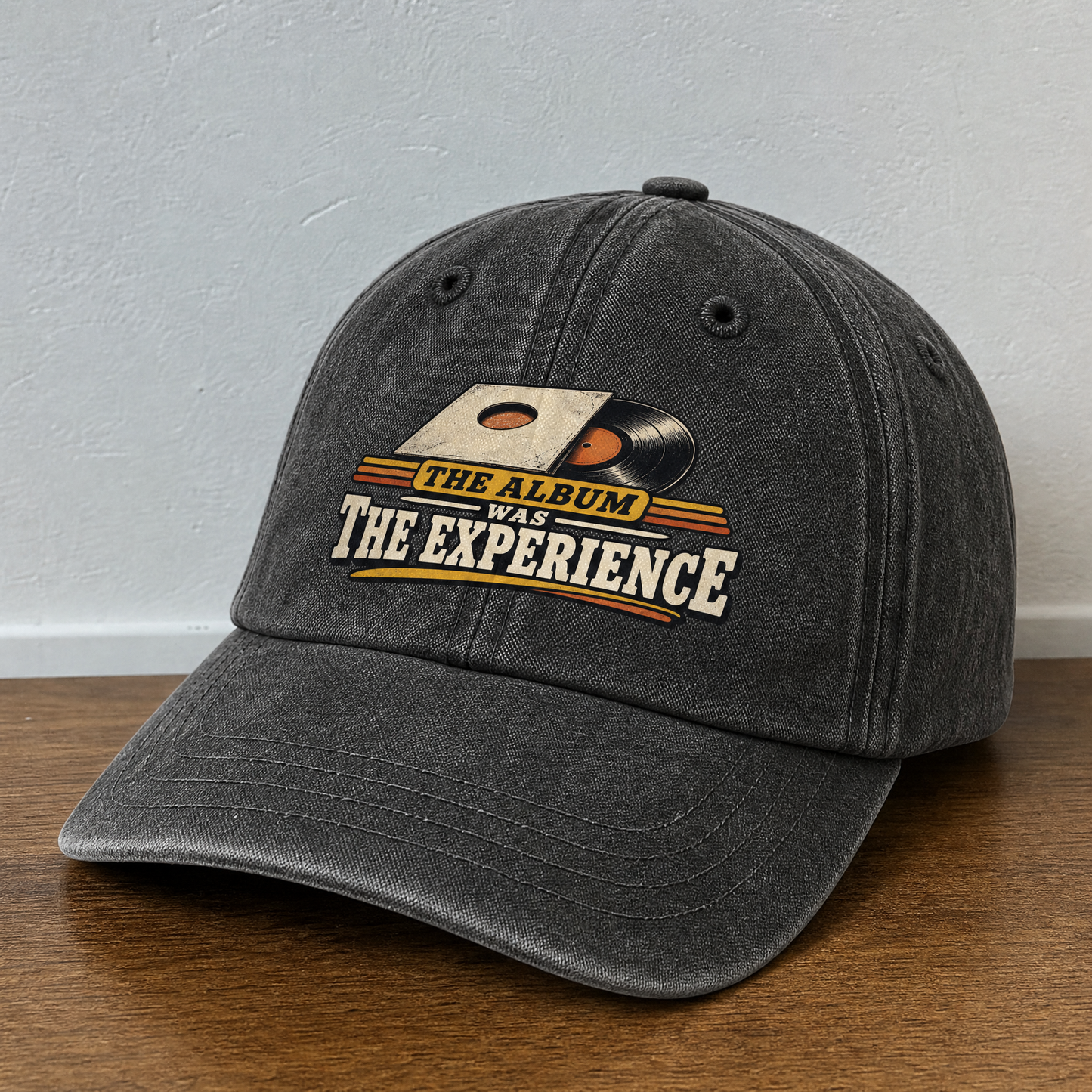 Black vintage washed cap with printed The Album Was The Experience design, angled view.