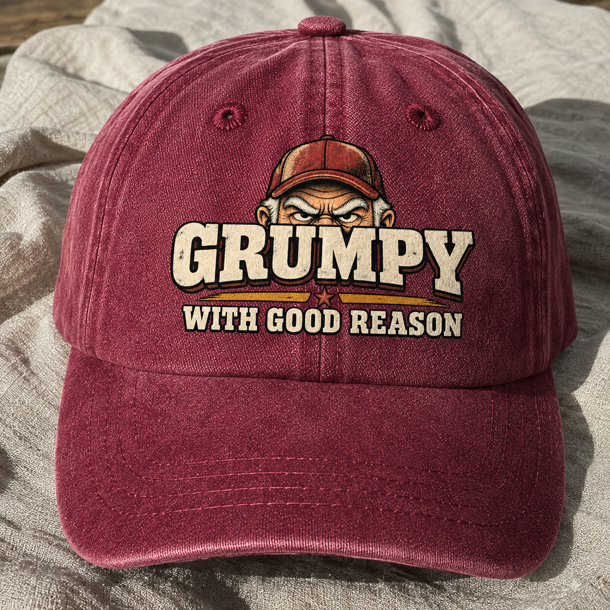Burgundy vintage washed cap with printed “Grumpy With Good Reason” slogan, front angle view