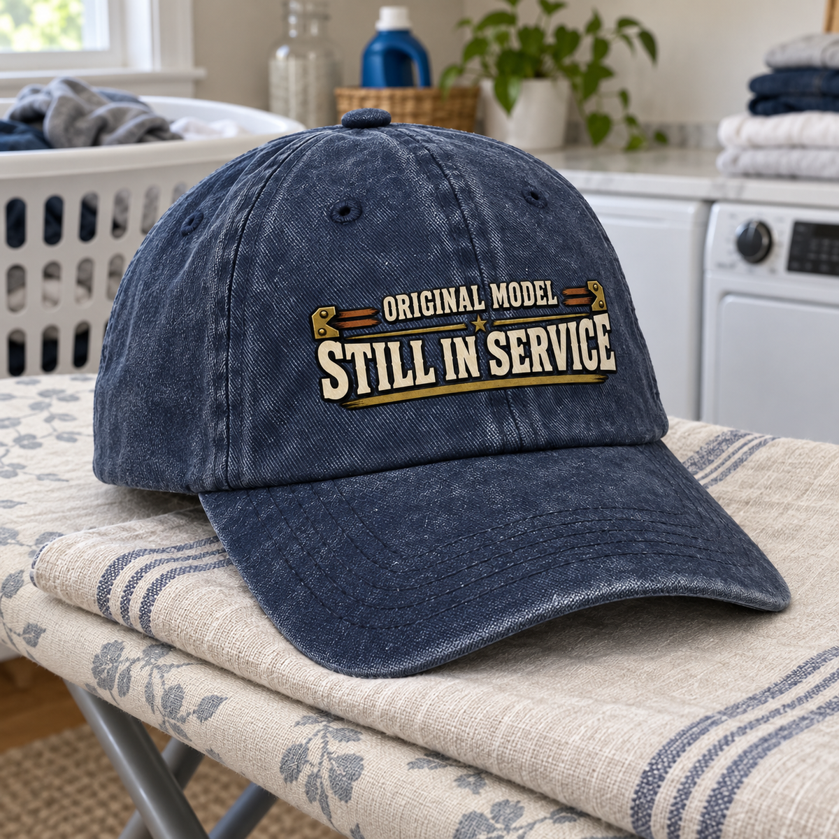 Navy vintage washed cap with printed Original Model Still In Service slogan, angled view.