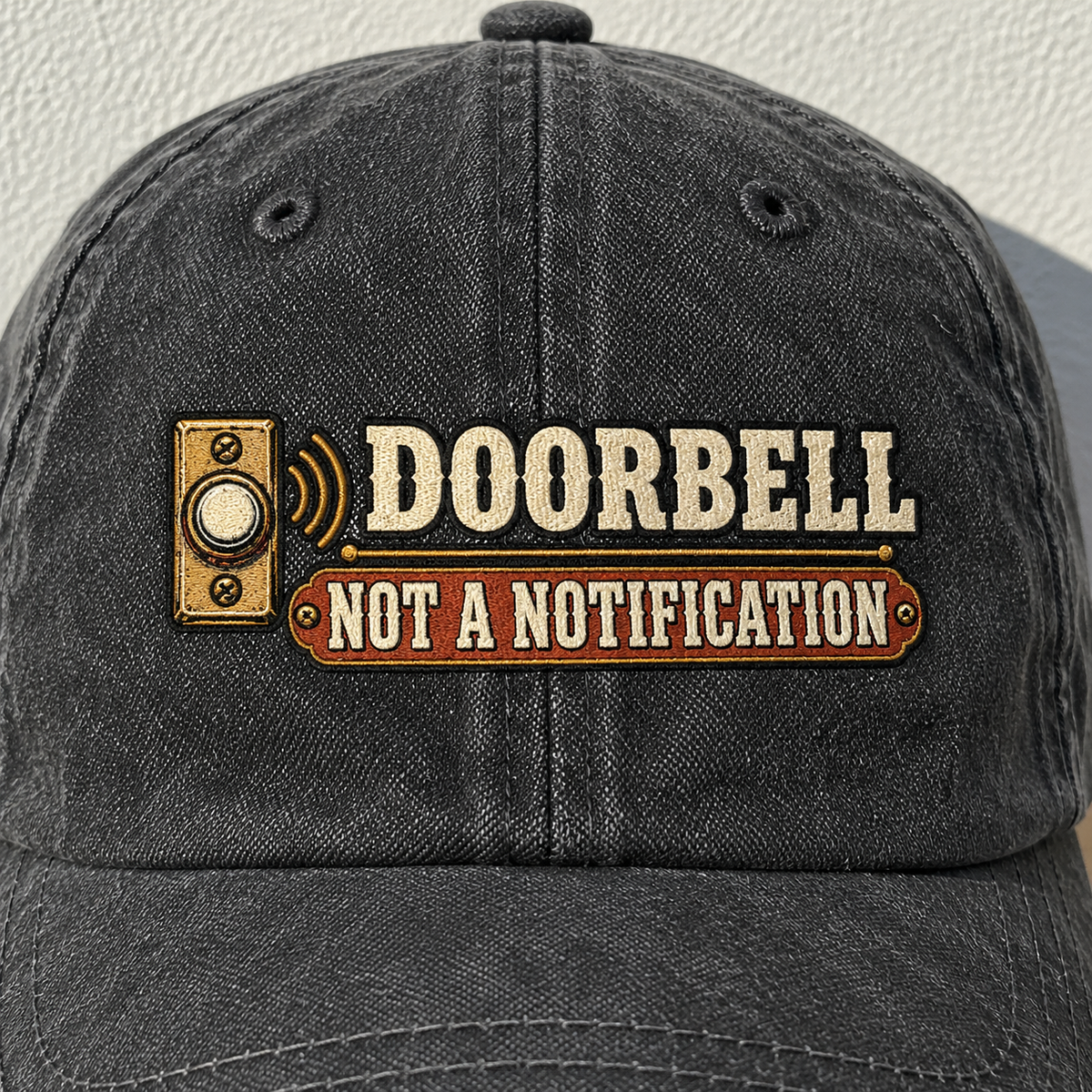 Black vintage washed cap with printed Doorbell Not A Notification slogan, front angle.