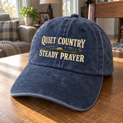 Navy vintage washed cap with printed Quiet Country Steady Prayer design, angled on table