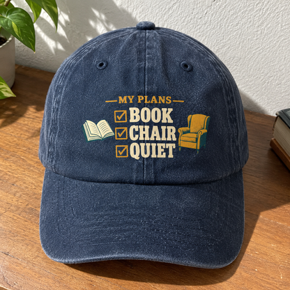 Navy vintage washed cap with printed MY PLANS BOOK CHAIR QUIET design, angled view