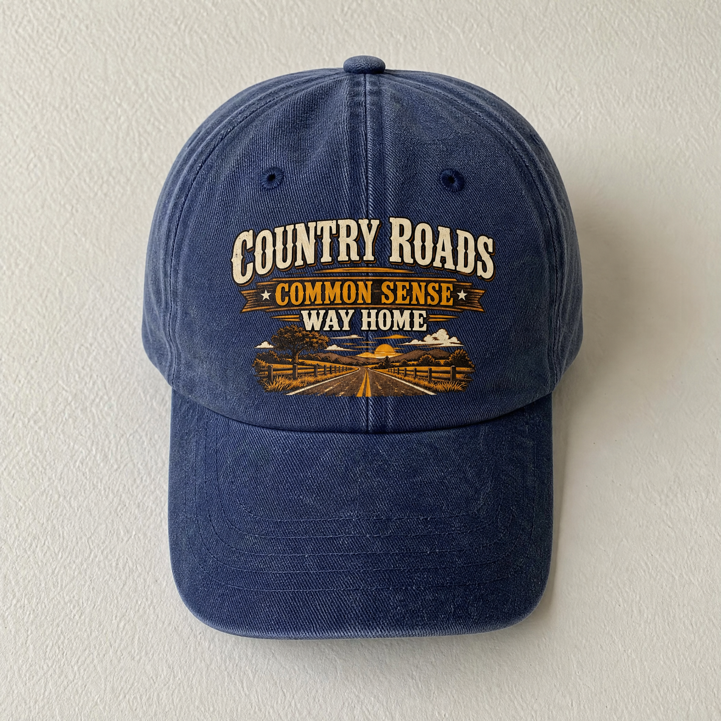 Close-up angle views of vintage washed cap with Country Roads. Common Sense Way Home printed design