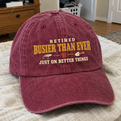 Burgundy vintage washed cap with printed Retired Busier Than Ever slogan, angled view.