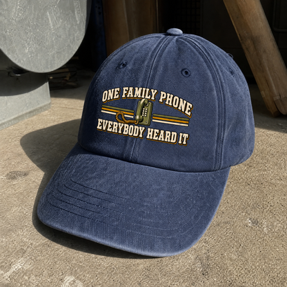Navy vintage washed cap featuring printed One Family Phone. Everybody Heard It slogan, angled view.