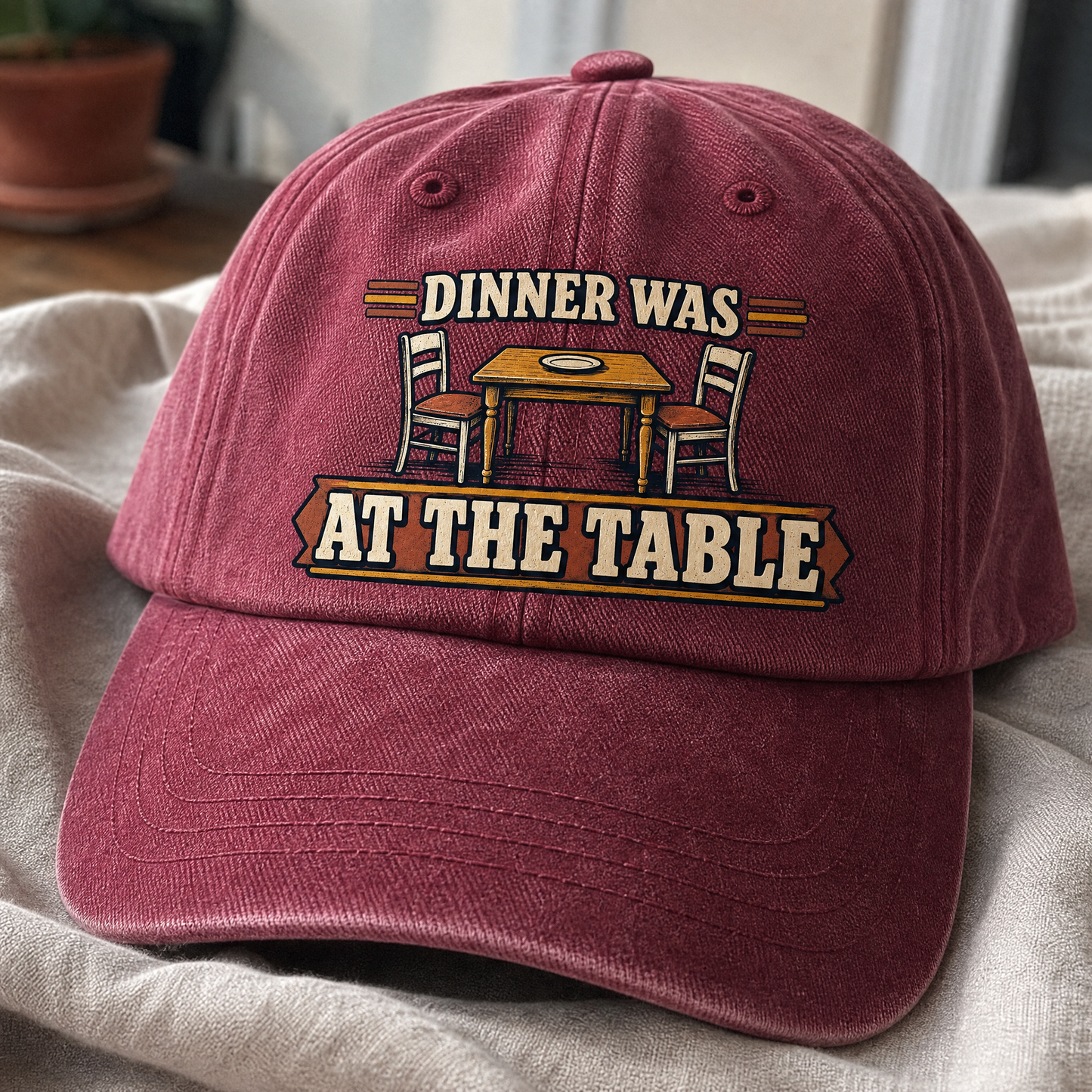 Burgundy vintage washed cap with printed Dinner Was At The Table design, angled view