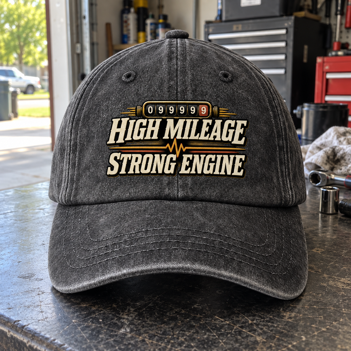 Front view of charcoal vintage washed cap with printed High Mileage Strong Engine design.