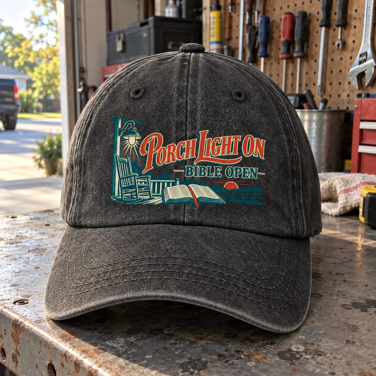 Front view of black vintage washed cap with printed Porch Light On Bible Open design.